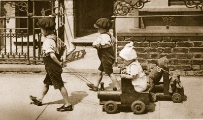 Bambini che giocano per strada: ragazzi che tirano carretti da English Photographer